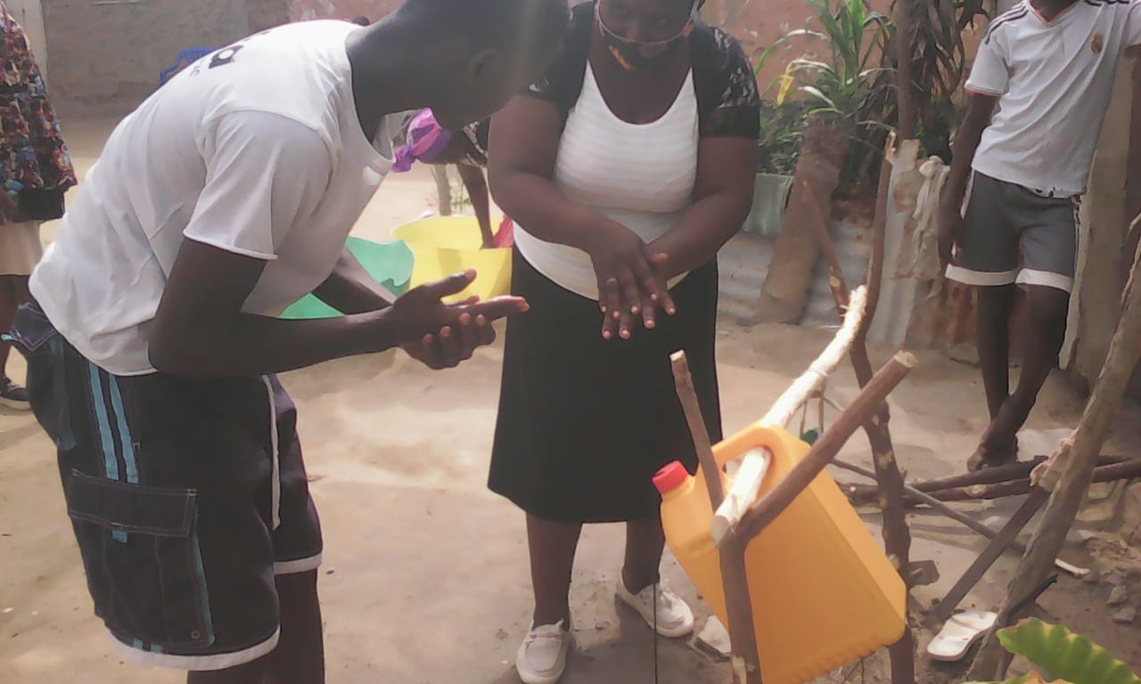 Demonstrating the correct way to wash hands to a family with a new tippy tap system